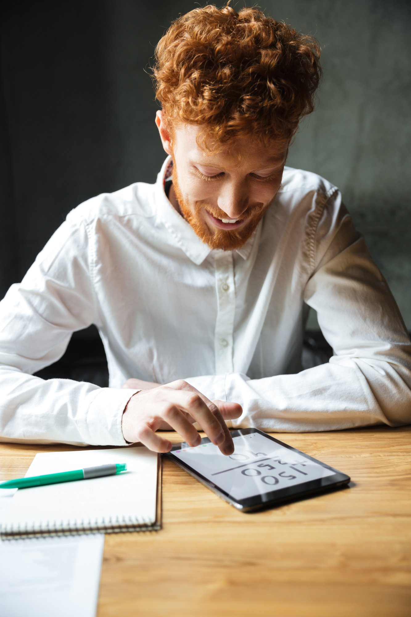 close-up-photo-young-happy-readhead-bearded-man-using-digital-tablet-workplace